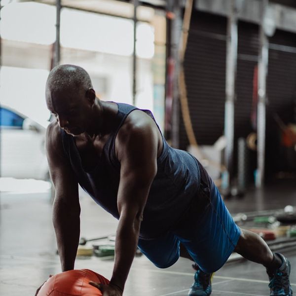 Man focused on a balance and strength exercise, showing concentration.